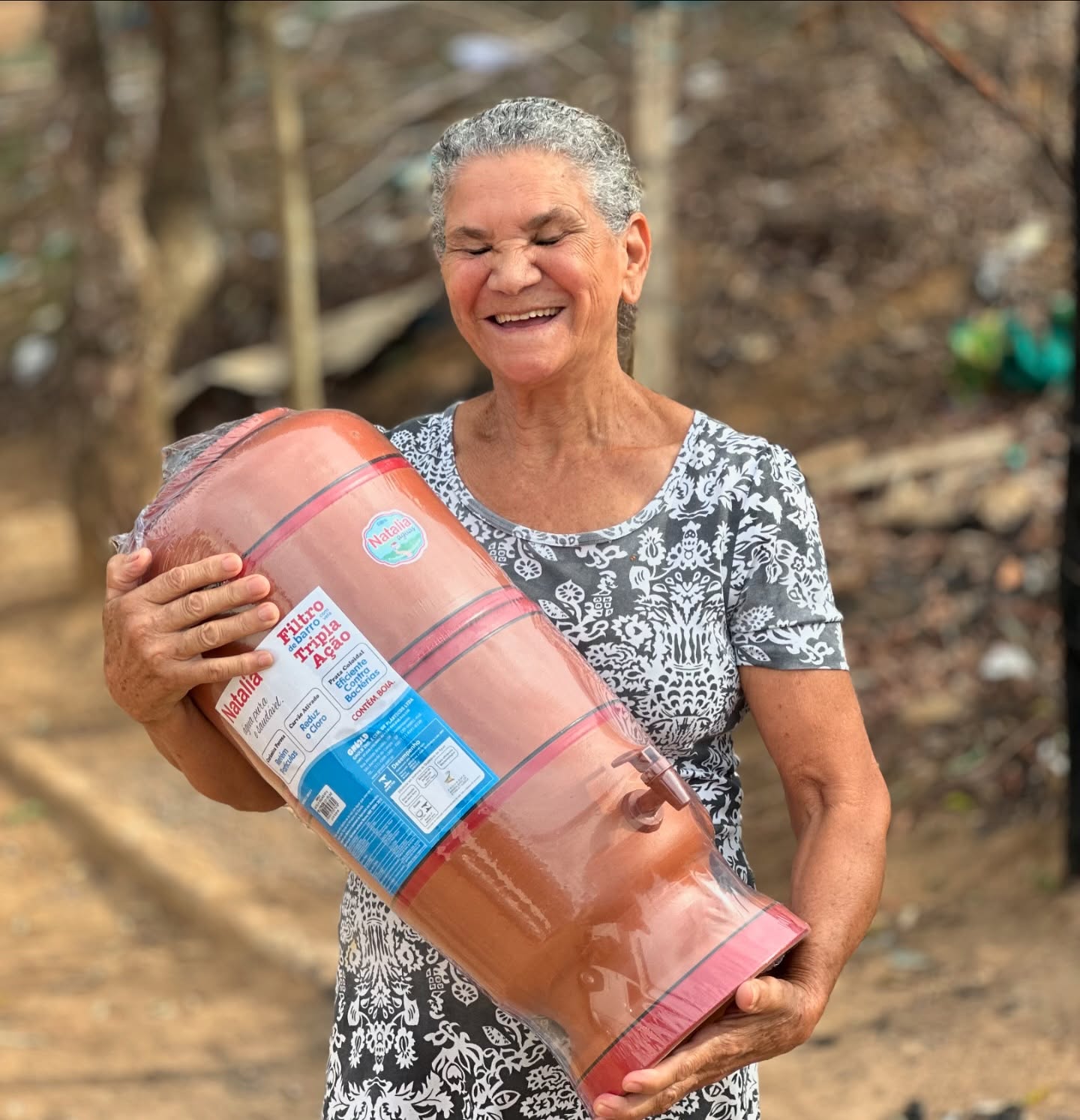 Moradora recebendo filtro de água em ação da rede