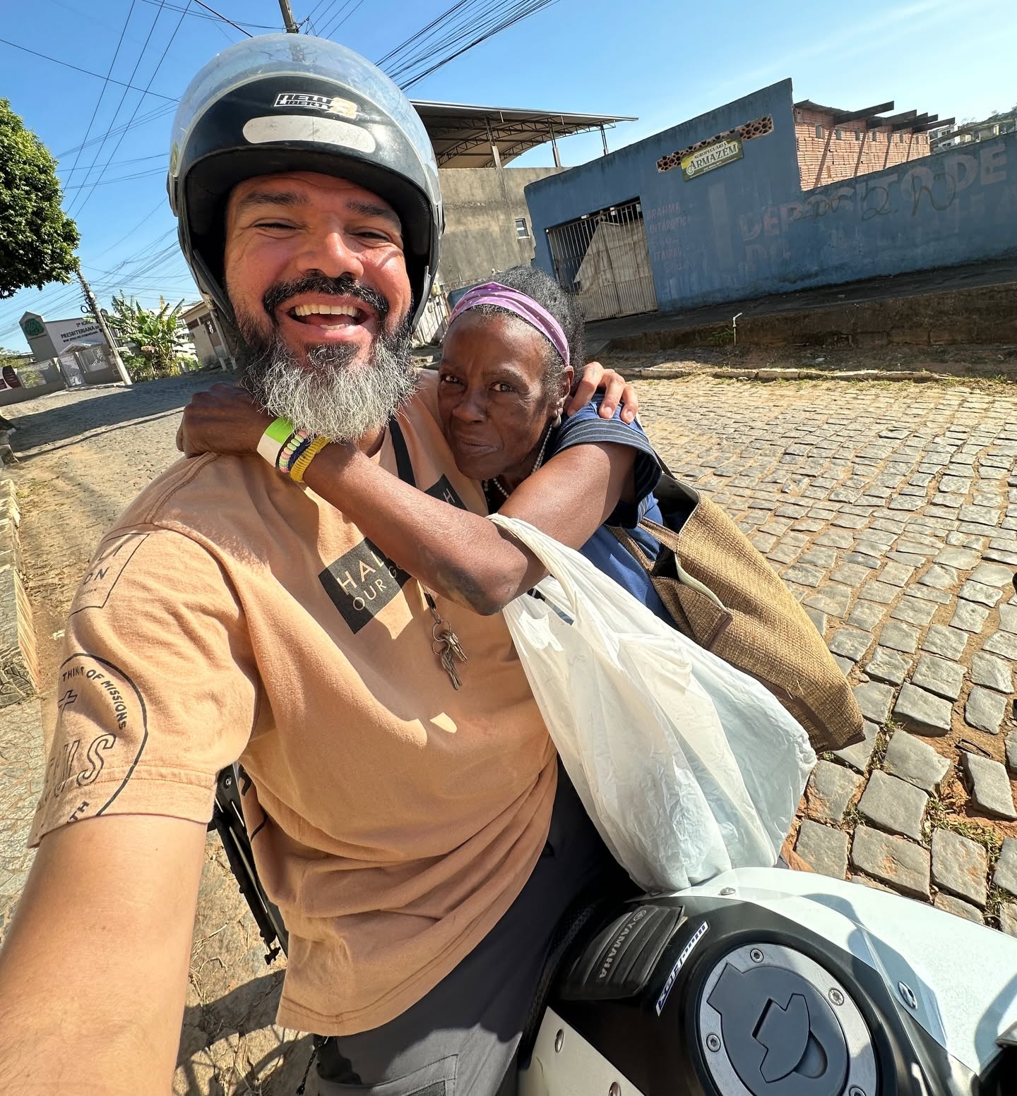 Voluntário levando moradora de moto para atendimento